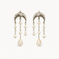 A pair of silver-toned dangle earrings with textured crescent-shaped tops, small pearl-like beads on chains, and larger teardrop pearl drops, shown on a plain light background.