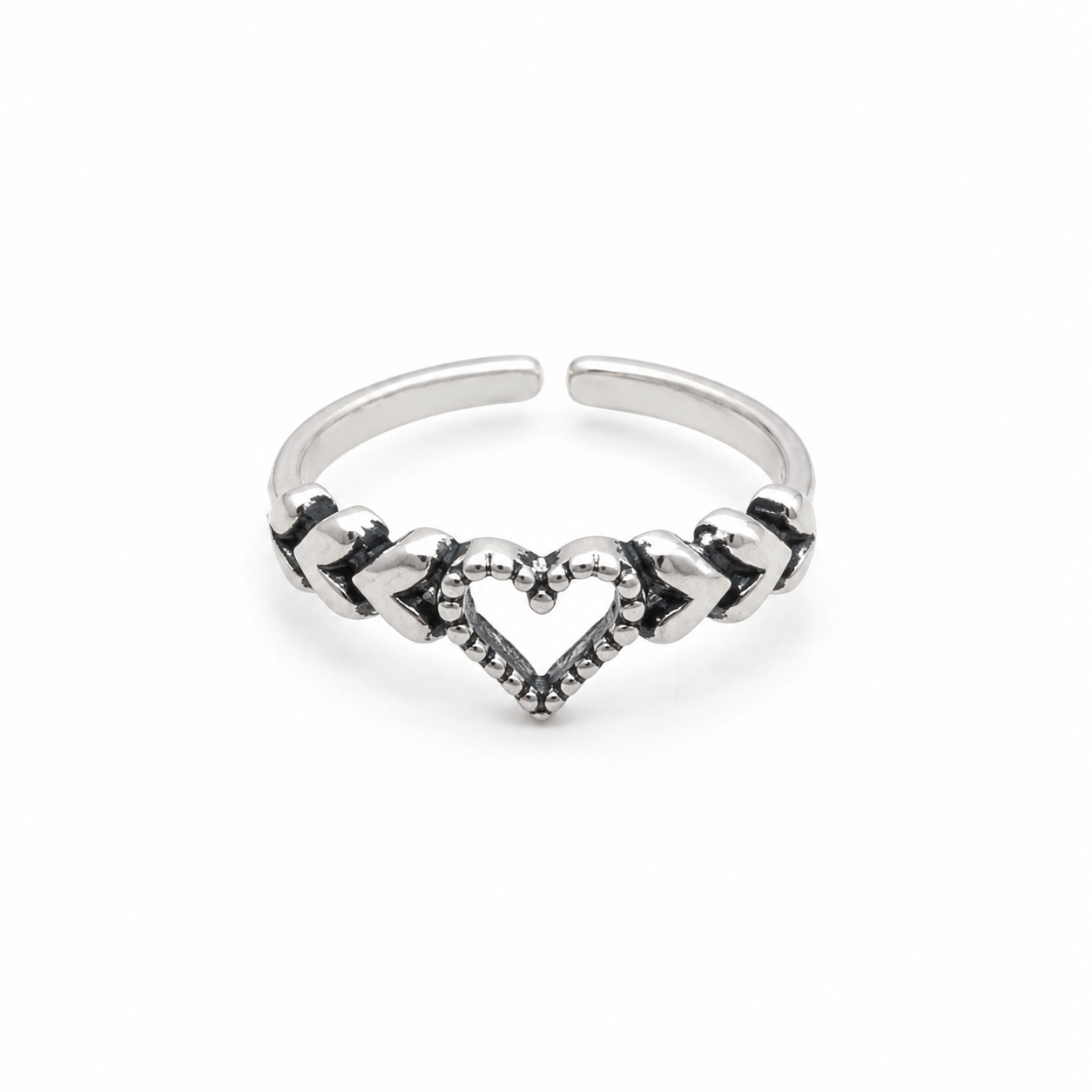 A silver adjustable toe ring featuring a central heart design with textured details and small dark accents, set against a plain white background.