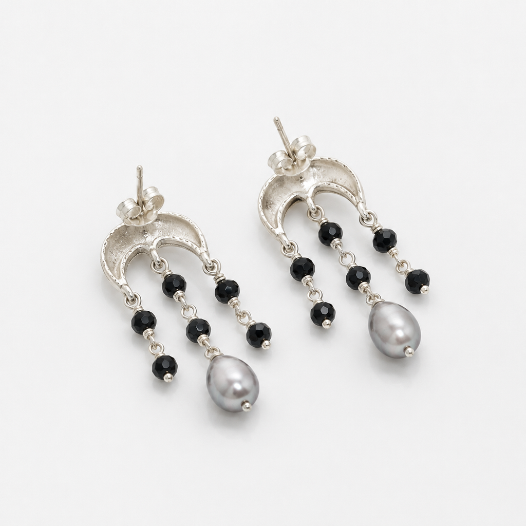 A pair of silver-tone dangle earrings with small black beads and a large gray pearl at the bottom, photographed on a clean white background.