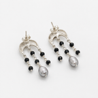 A pair of silver-tone dangle earrings with small black beads and a large gray pearl at the bottom, photographed on a clean white background.
