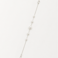 A delicate silver chain bracelet featuring a graduated sequence of white pearls, displayed diagonally on a clean white background.