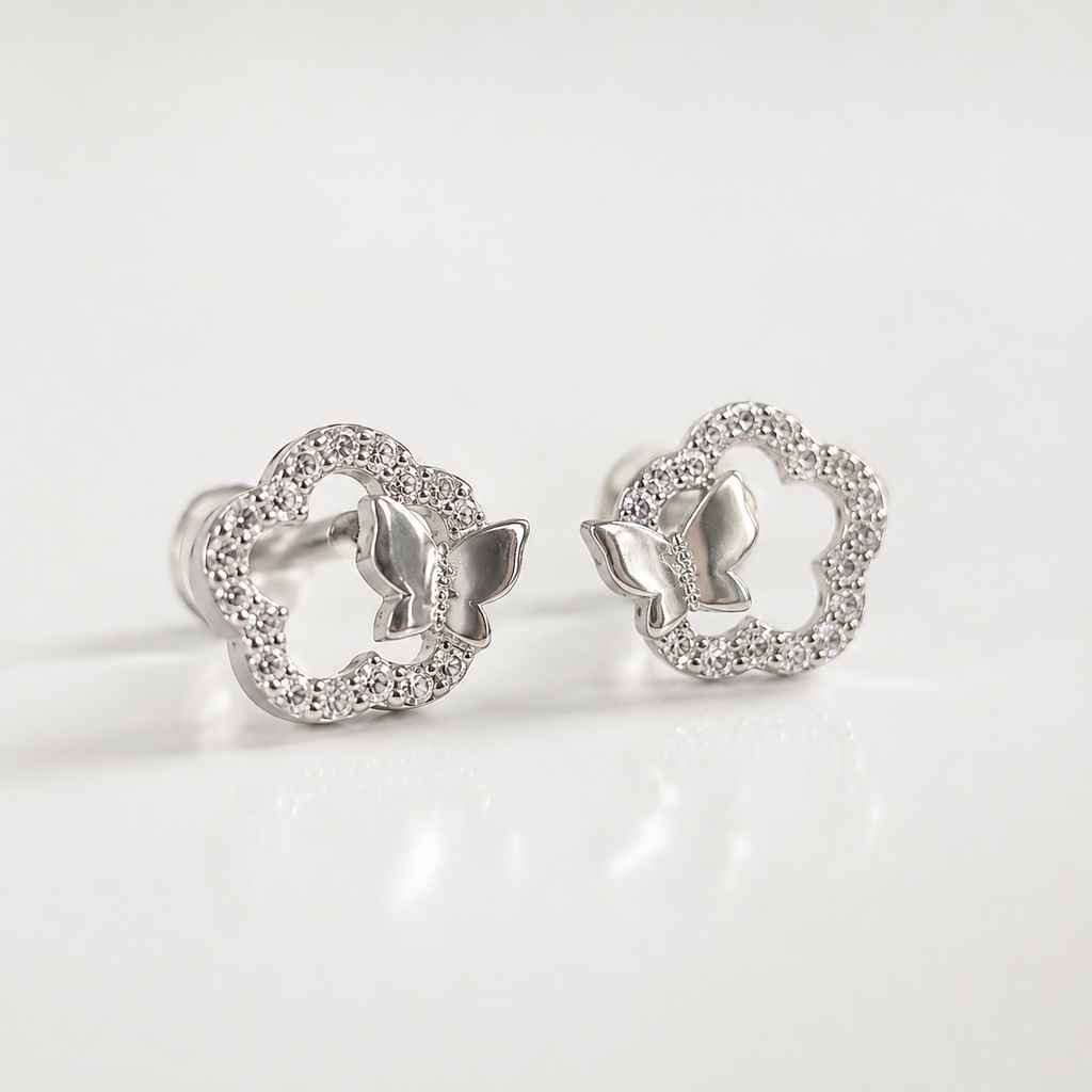 A pair of silver butterfly stud earrings with openwork floral outlines paved with small clear stones, shown on a clean white background.