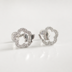 A pair of silver butterfly stud earrings with openwork floral outlines paved with small clear stones, shown on a clean white background.