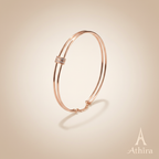 Rose gold kada on soft beige background with Athira logo