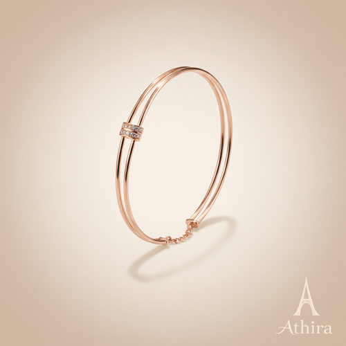 Rose gold kada on soft beige background with Athira logo