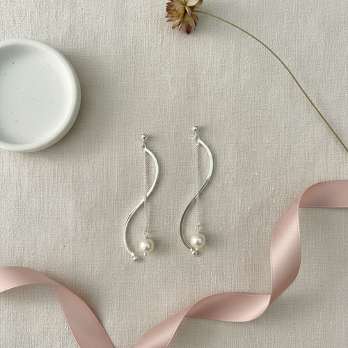 S-Curve Pearl Earrings — Flat Lay Editorial